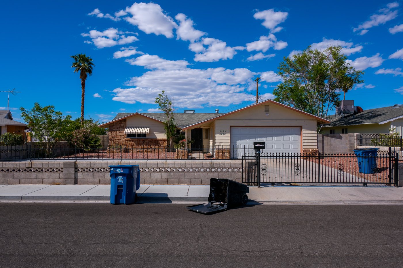 A suburban street under big clouds